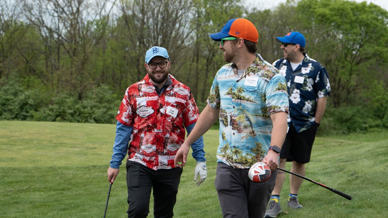 three men on golf course in floral shirts