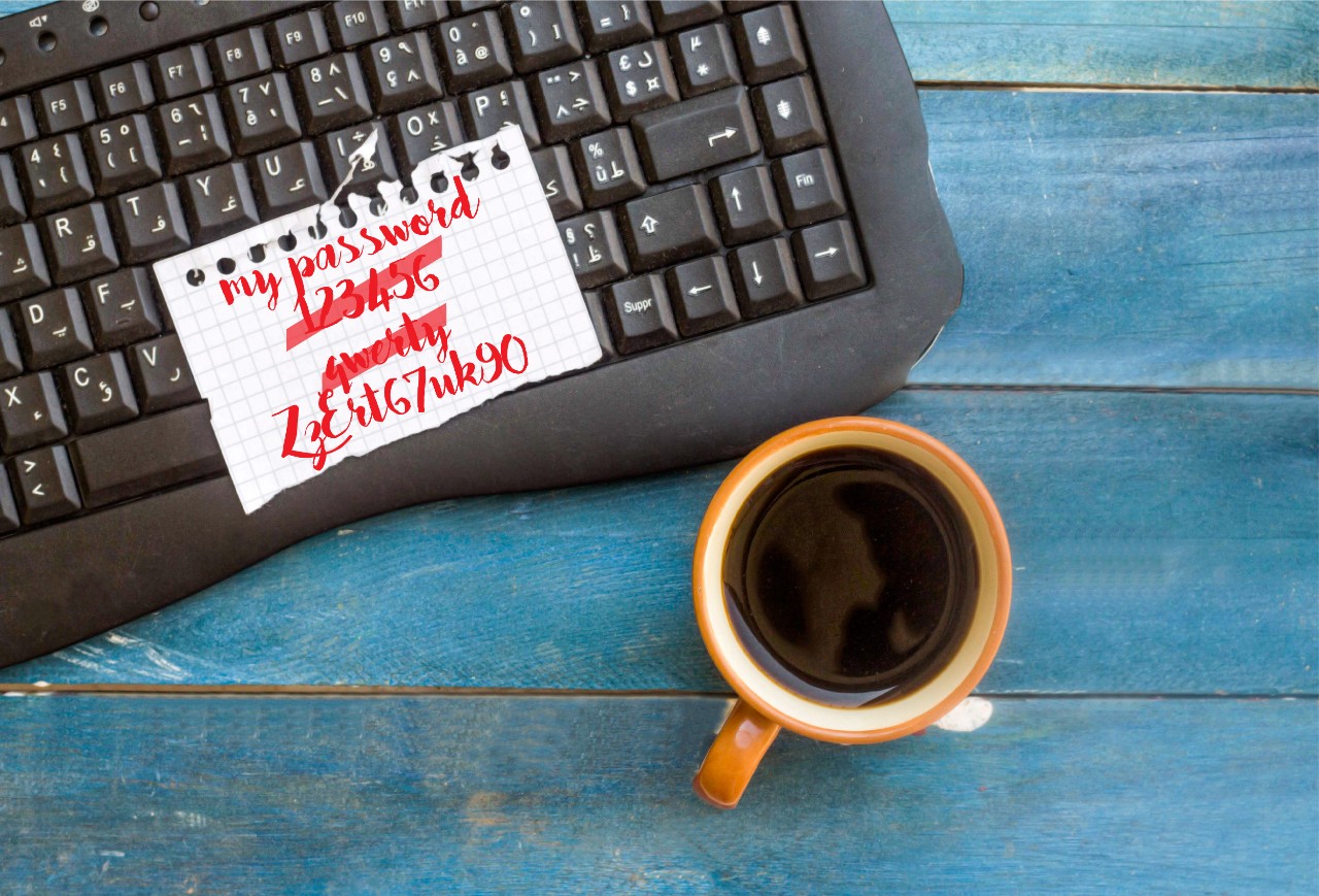 Keyboard with multiple post-it notes displaying written passwords.