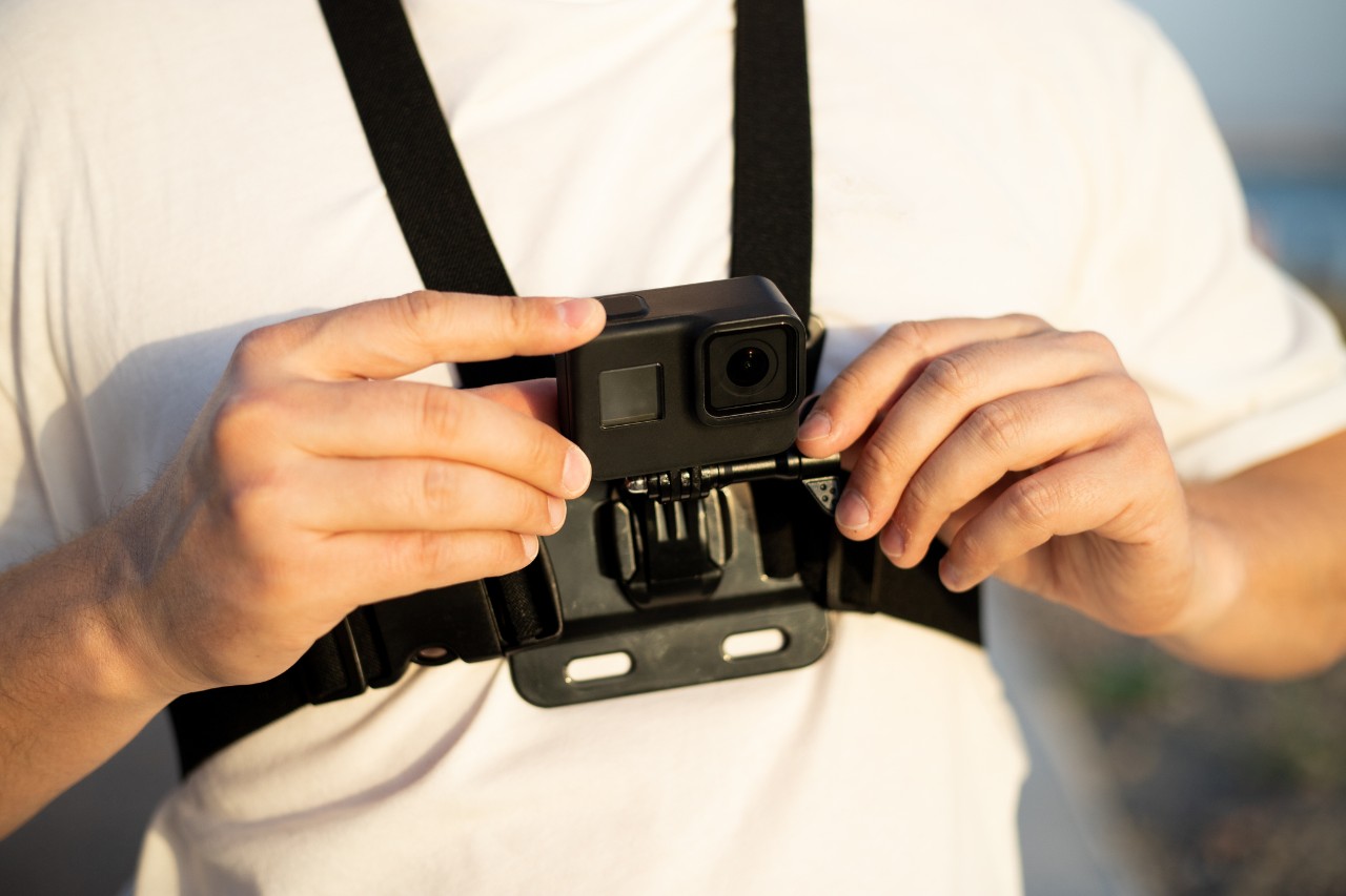 person in white t-shirt wearing a body camera 