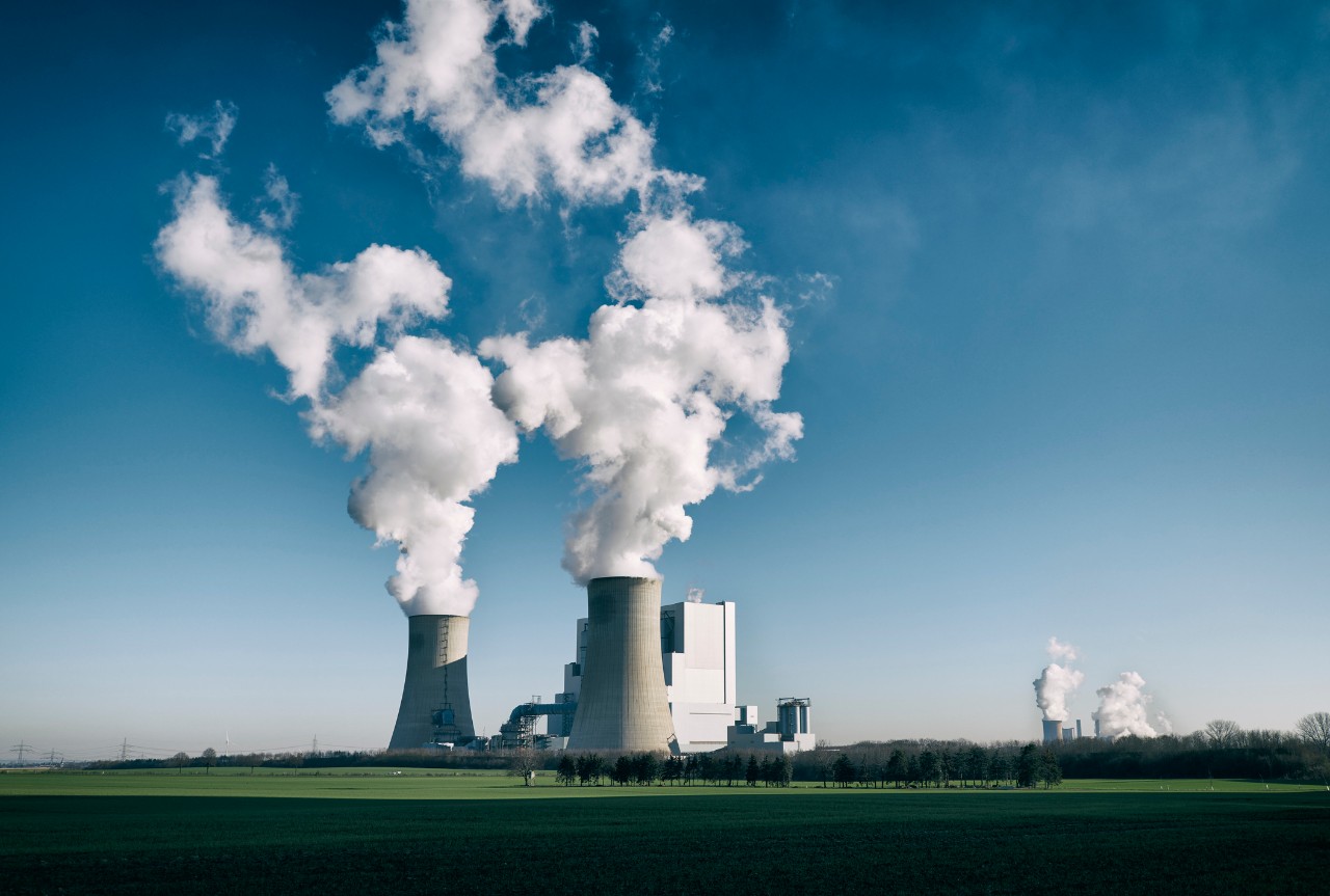 Steam rises from cooling towers at a coal-fired power plant.
