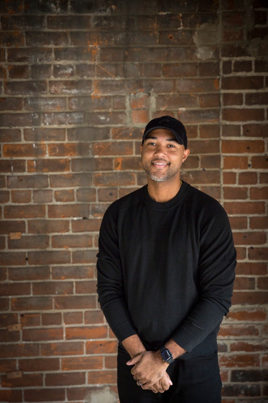 Sean Parker stands in front of a brick wall.