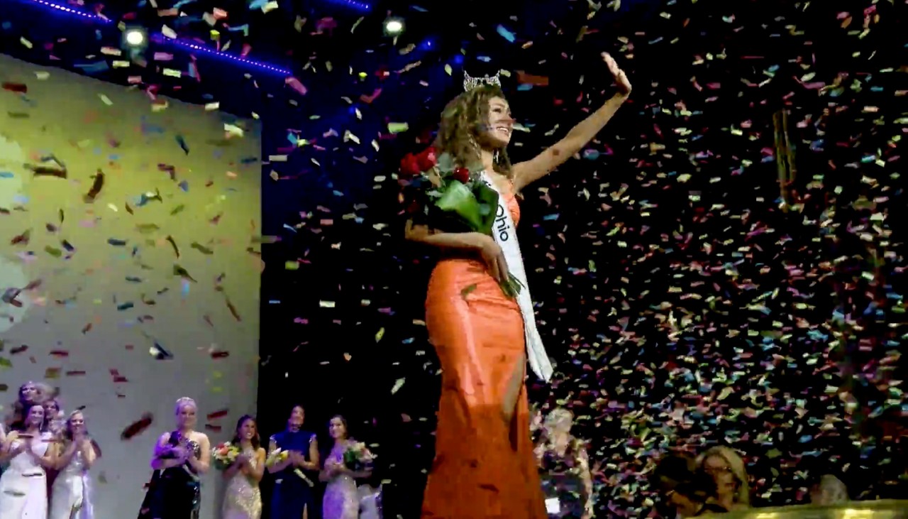 Stephanie Finoti holds a bouquet of flowers while wearing the Miss Ohio sash  on stage.