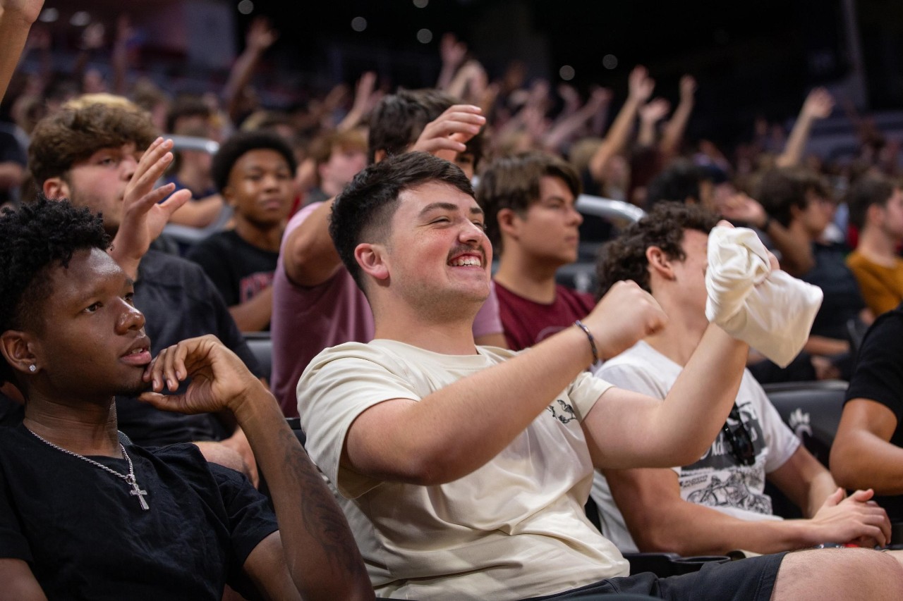 Image of several students cheering during new student convocation in Fifth Third Arena