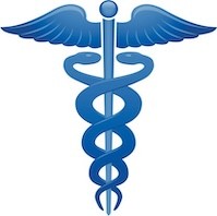 A gloved hand is holding up a Petri dish with bacteria growing inside