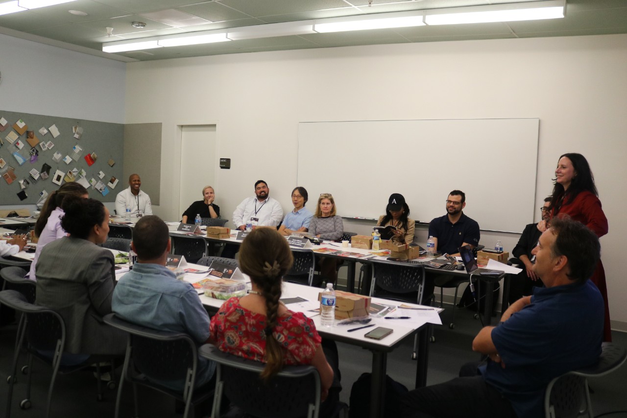  about two dozen people seated in a classroom participating in a workshop 
