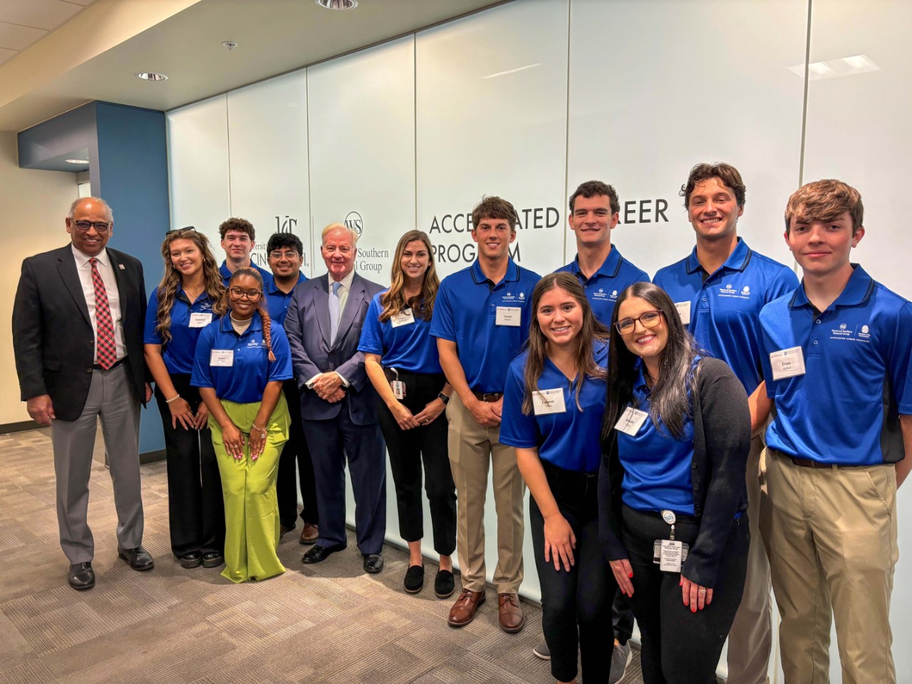 UC co-op students working at the W&S Accelerated Career Program stand with President Neville Pinto and John Barrett.
