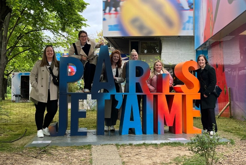 students posing by paris jet'aime sign
