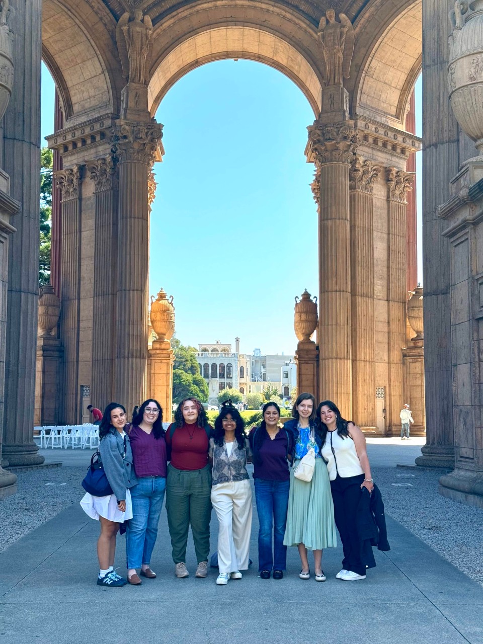 NIS students pose in front of a large arch.