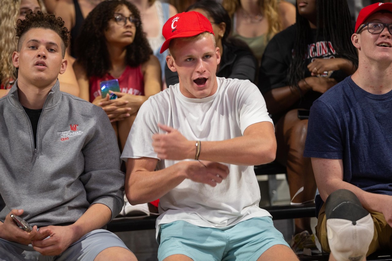 many students at fifth third arena and image looks at a trio of students doing down the drive school cheer