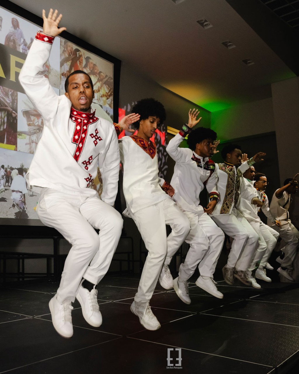 group of students dressed in matching white perform a dance