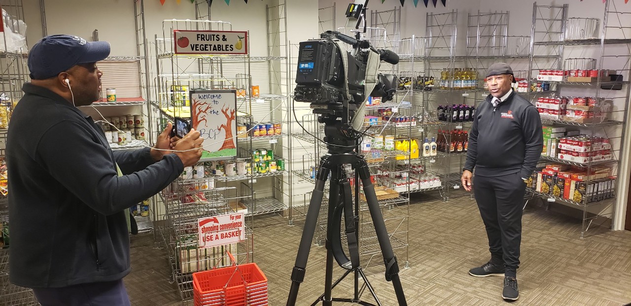 TV Journalist with camera equipment interviews Daniel Cummins in Bearcat Pantry