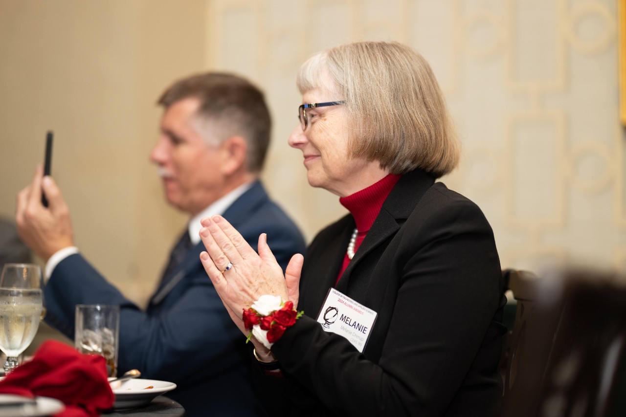 Melanie Drerup claps for a presenter at the CEAS alumni awards event. 
