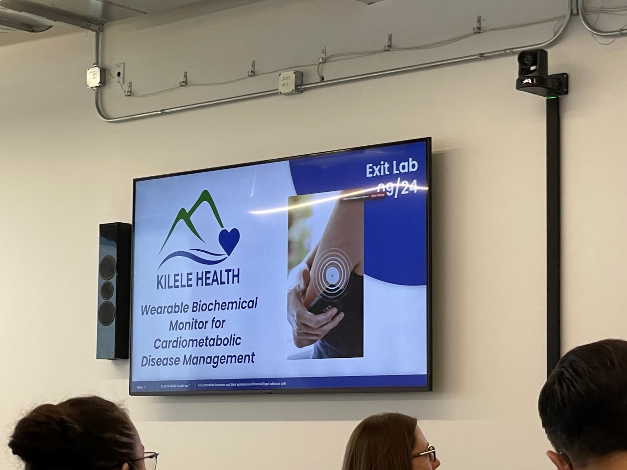 A television screen shows a Kilele presentation slide with the business' logo.