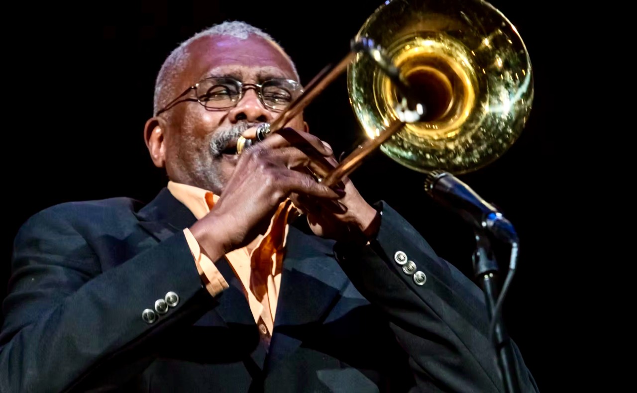 Head and shoulders portrait of UC CCM's Marc Fields playing a trombone.