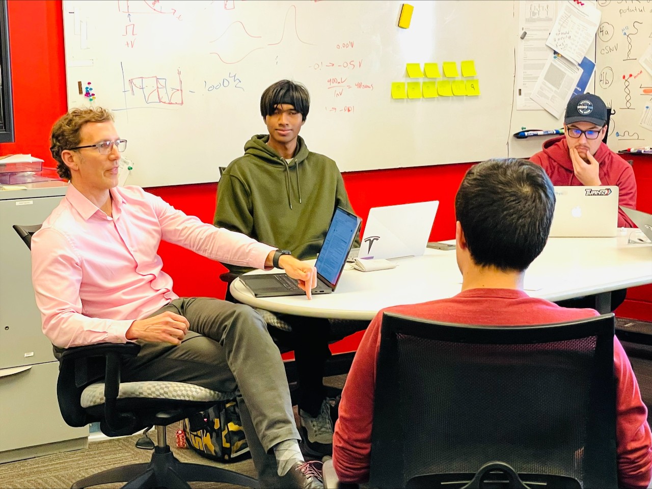 Jason Heikenfeld sits with UC students.