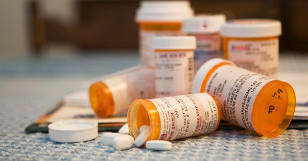 Various prescription pills and pill bottles scattered around 