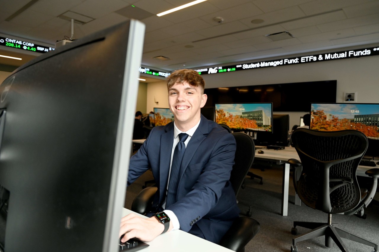 Lindner student Landyn Hopper in a blue suit sits at a computer terminal.