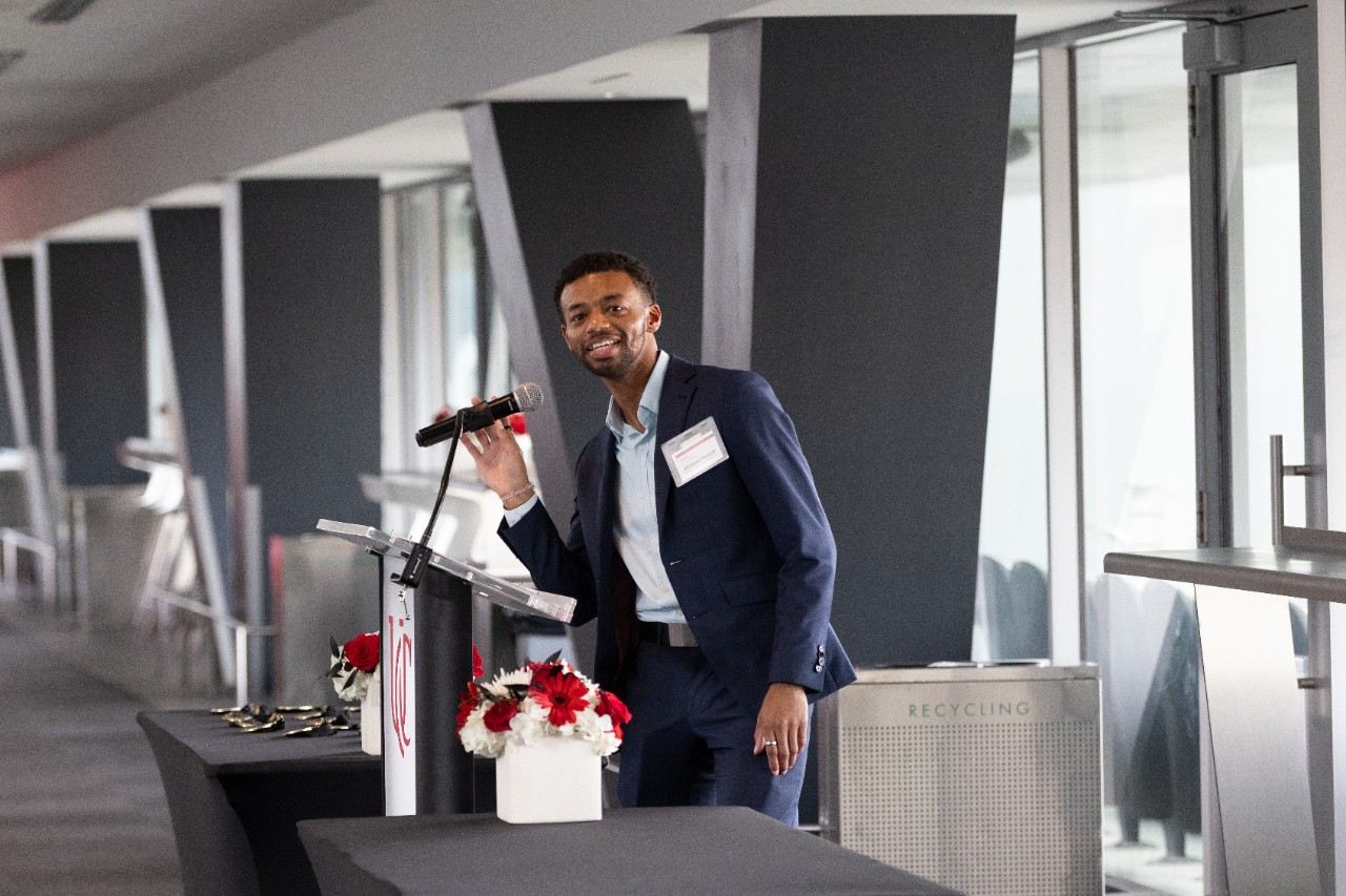 Michael Hunter stands at a podium and speaks into the microphone 