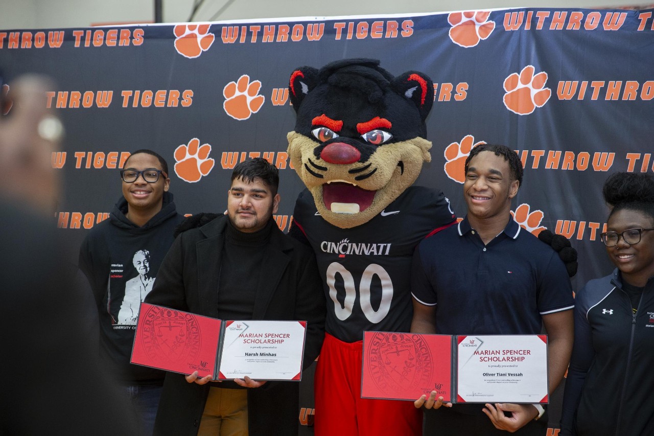 Two male Marian Spencer Scholars pose for a photo at Withrow High School with the Bearcat Mascot