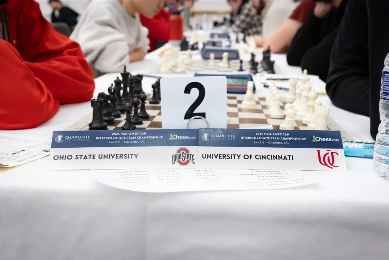 A chess board is framed by placards for Ohio State University and the University of Cincinnati.