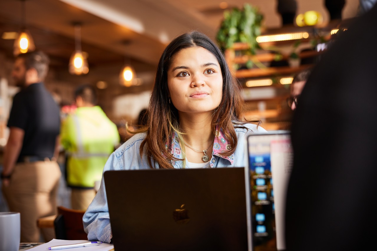 Young woman college student using laptop in coffee shop