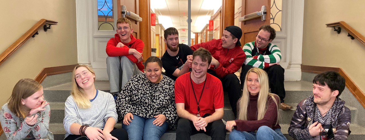 a group of students sits on steps in the CECH Teachers-Dyer building