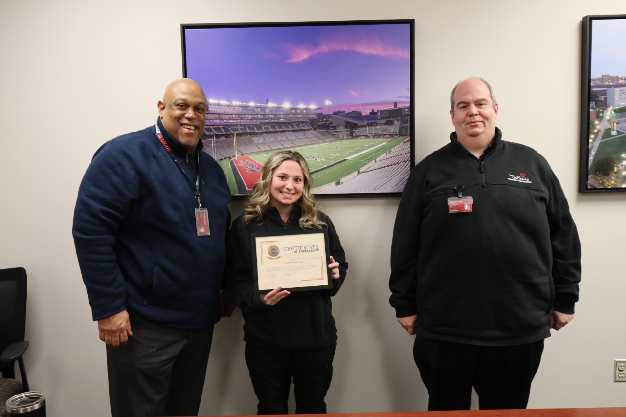 From left, Chief Eliot Isaac, Emergency Communications Dispatcher Kylee Beccaccio and Emergency Communications Manager Ted Langdon pose with Beccaccio's SmartSave Award.
