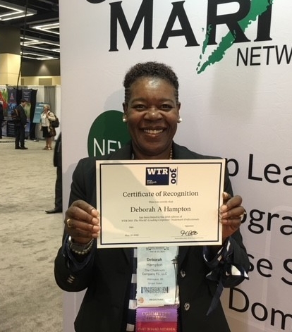 Deborah Hampton smiling while holding a certificate