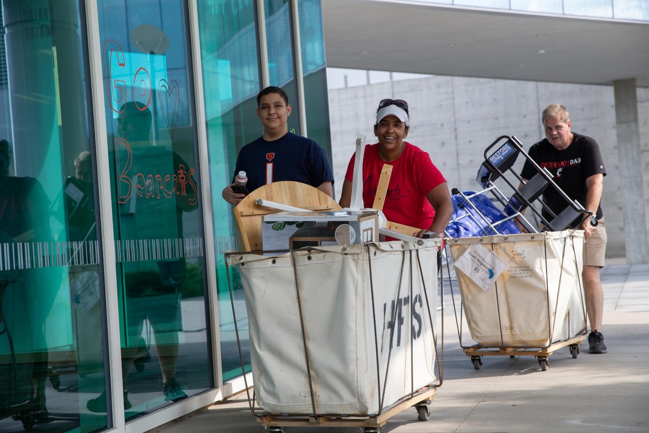 Families moving onto UC's campus, pushing carts, showcasing what to bring to college