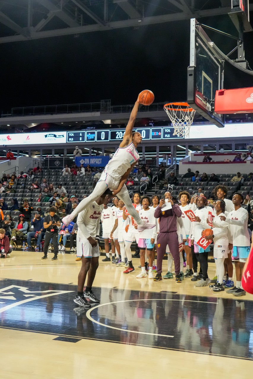 Male basketball play does a slam dunk in Fifth Third Arena