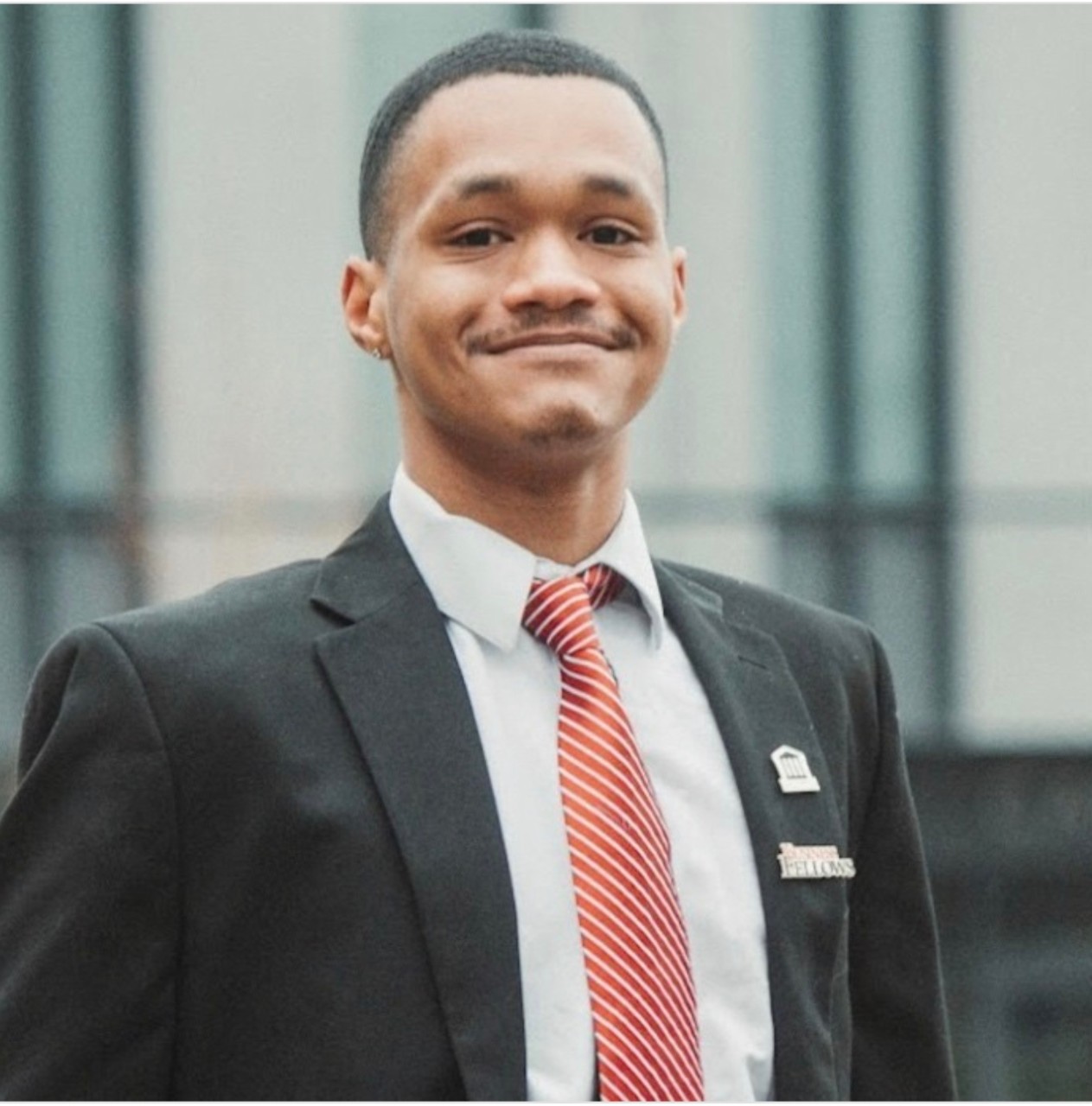 Khalid Davis wearing jacket, red and white tie