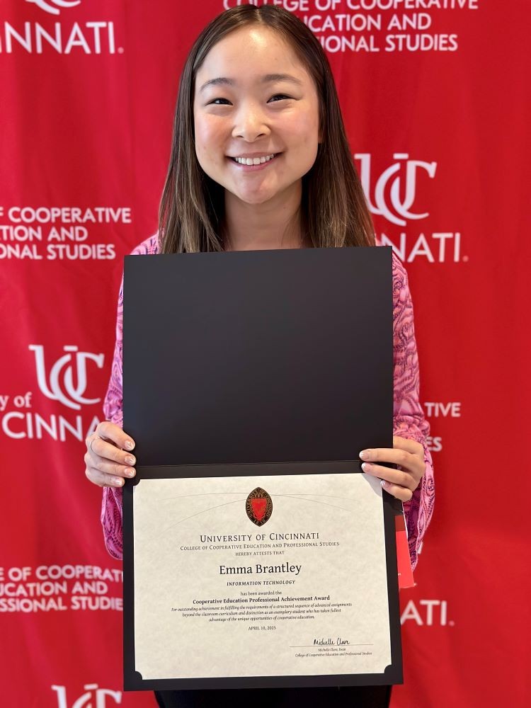 young woman smiling and holding a certificate