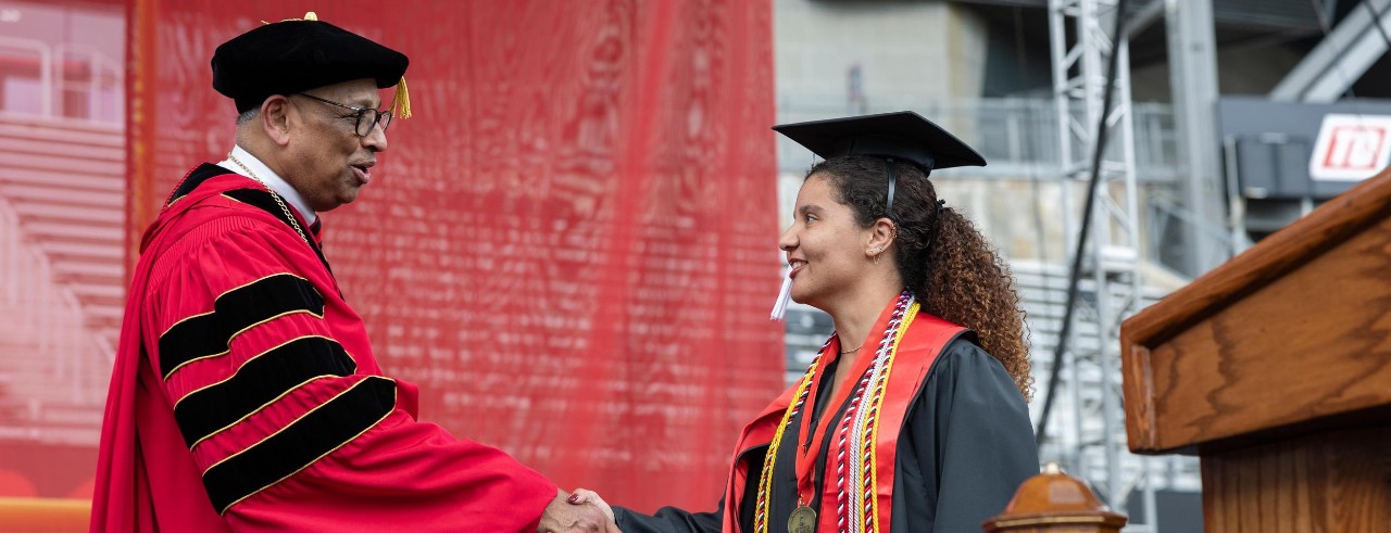 UC President Neville Pinto shakes Katelyn Cotton's hand during graduation