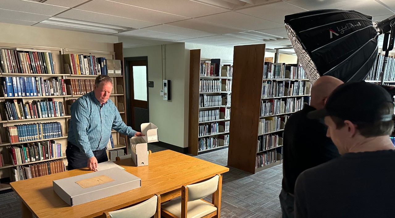 Chris Harter with ThinkTV movie crew looking at a manuscript of Theda Bara's life