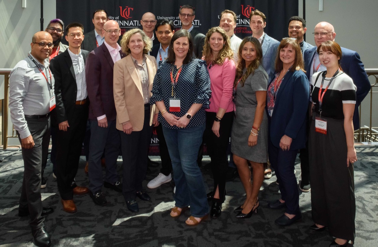 Data analytics professionals and speakers stand in professional dress at the summit