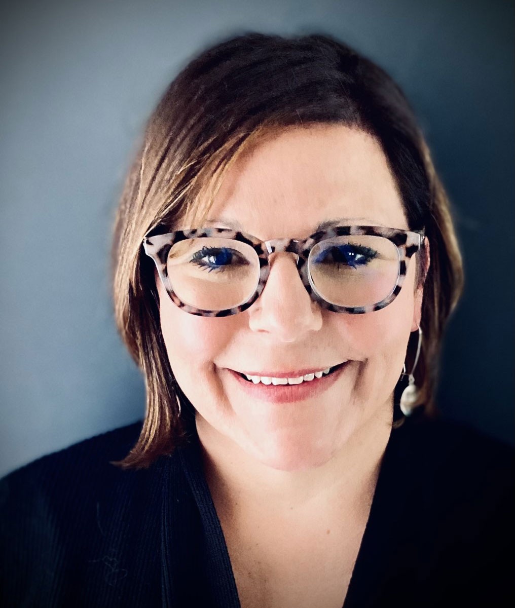 Headshot of Dean Michelle Clare wearing glasses and looking at camera