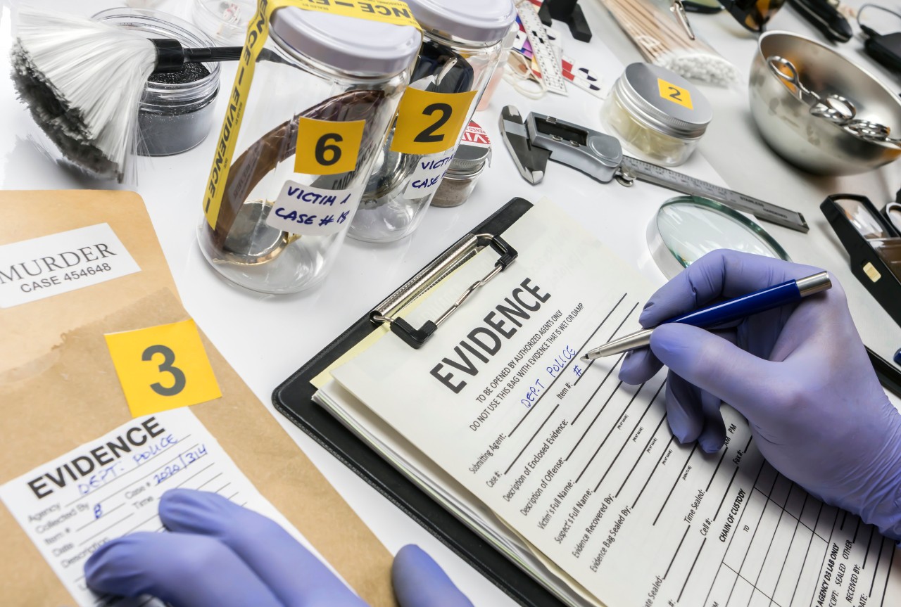 Image showing police evidence with a clip board with an evidence permision form being filled out by an official