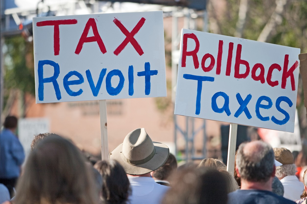 Crowd protesting with Rollback Taxes signage