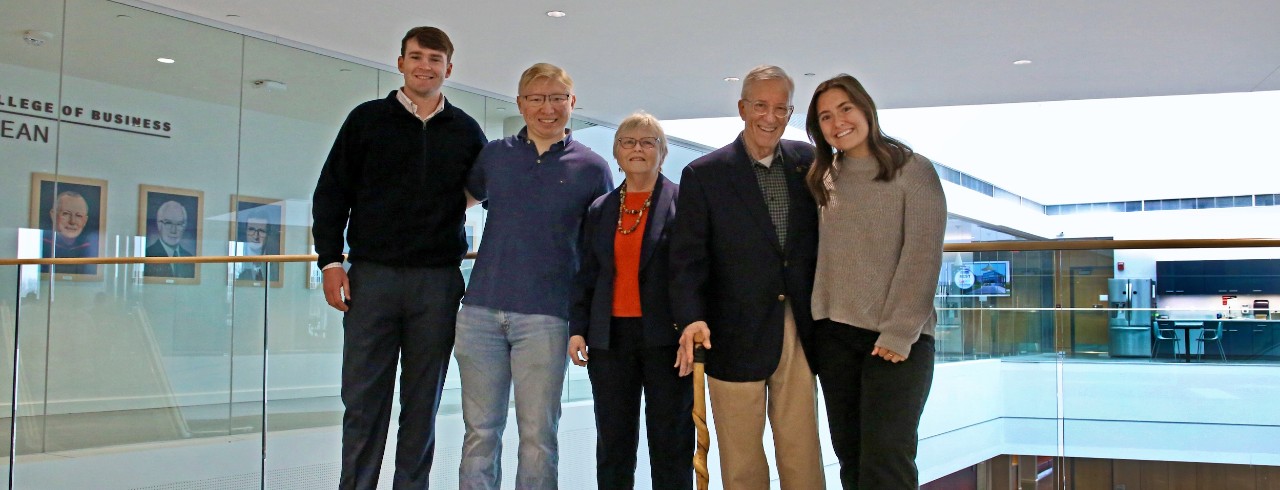 Five people standing in the College of Business