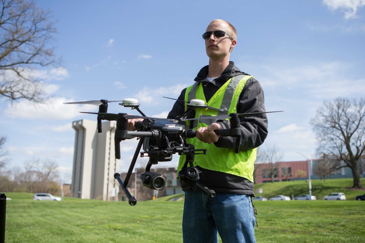 Bryan Brown (beard), research associate in UC's College of Engineering and Applied Science (CEAS), and UC engineering student Austin Wessels demonstrate a drone used as part of CEAS's multi-year contract with the Ohio Department of Transportation to study traffic.