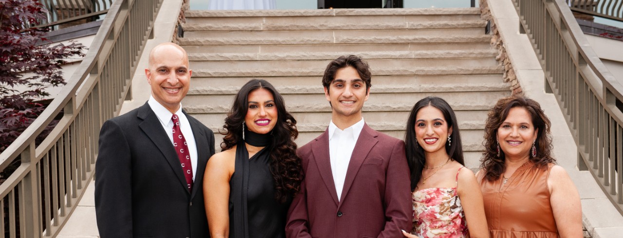 Five people standing in front of stairs and smiling