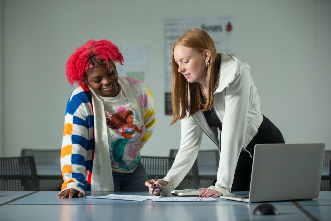 Communication Design student (DAAP) Megan Fein is a co-op in the Bearcats Student Creative Agency, shown here with DAAP student Yazmyn Kitchen.