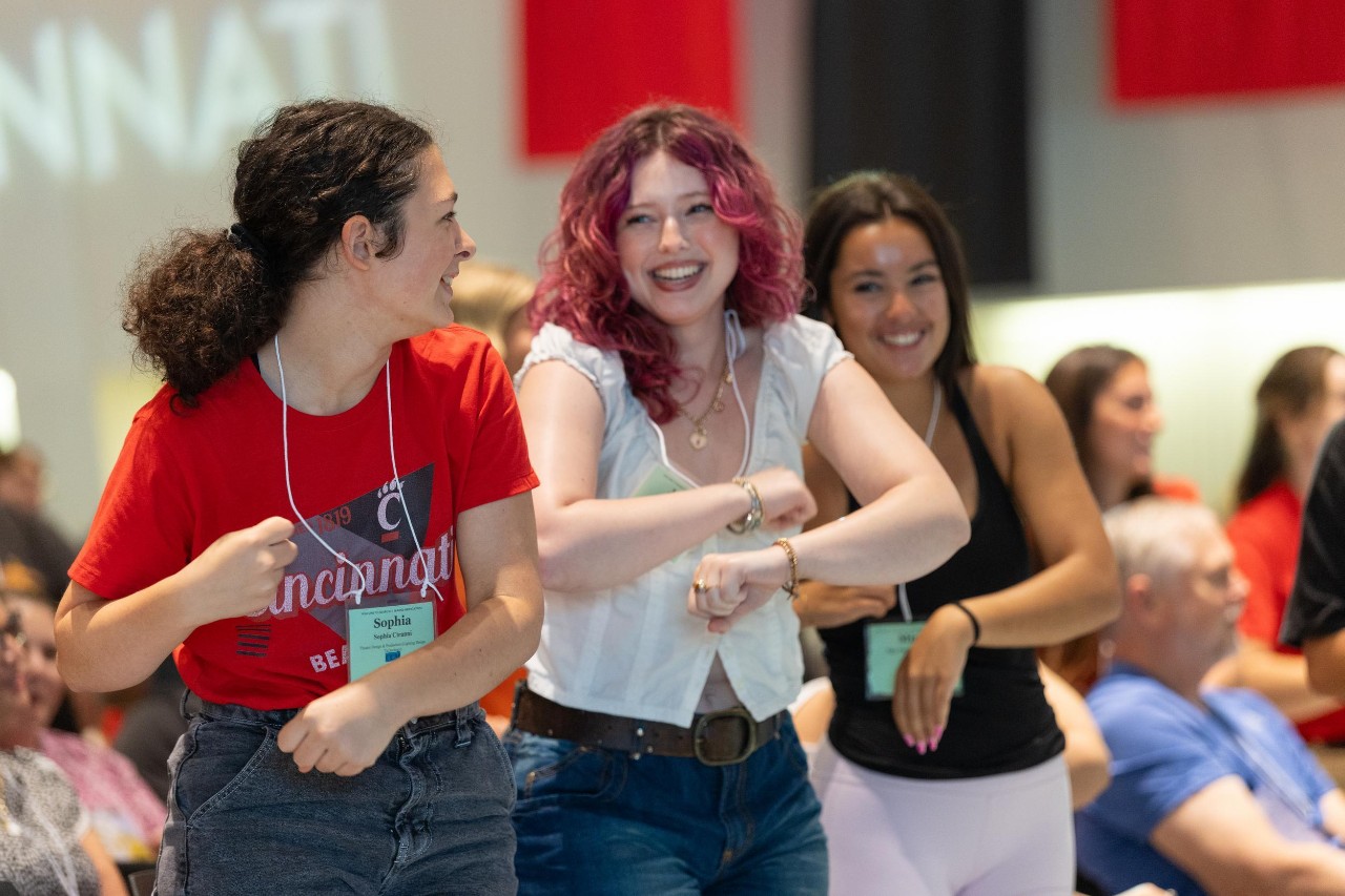 UC students at orientation doing a cheer