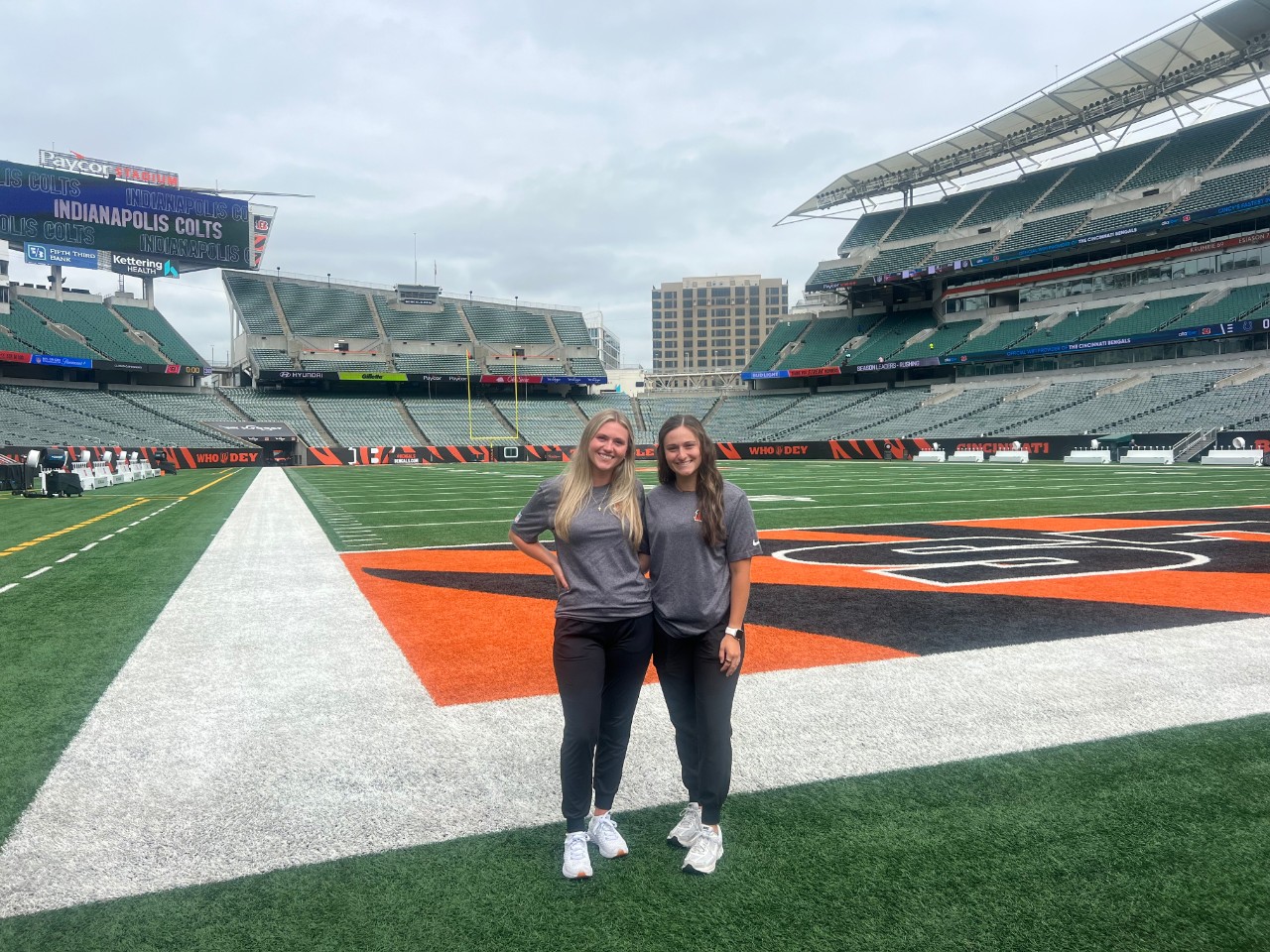 Two UC students who interned with the Bengals during training camp on the field at Paycor Stadium
