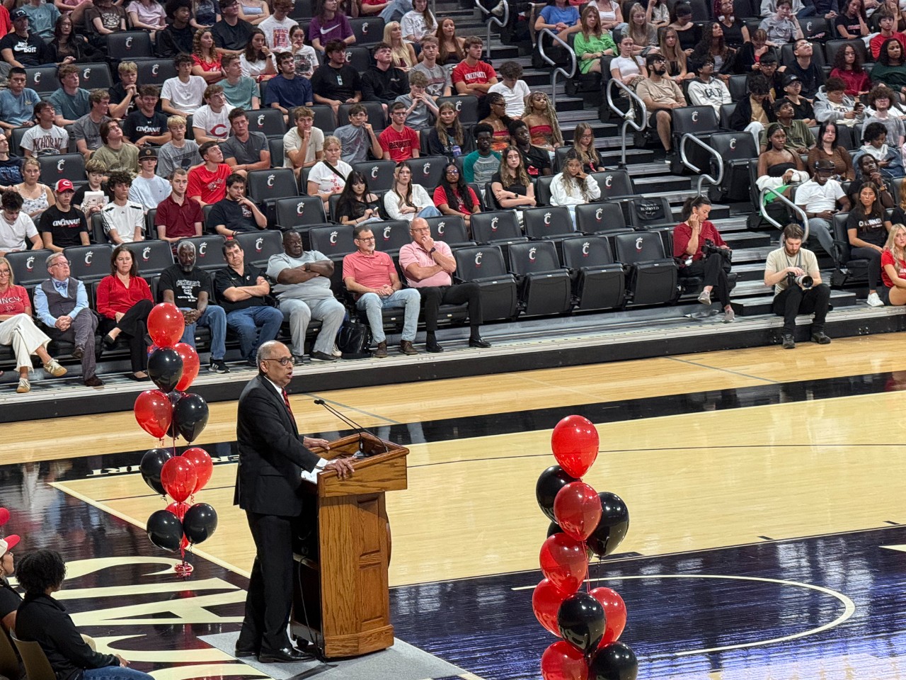 President Neville Pinto stands at a podium in front of thousands of UC students at Fifth Third Arena.
