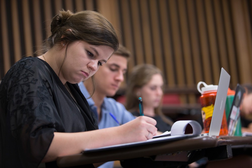 Students taking notes while learning scholarship essay tips