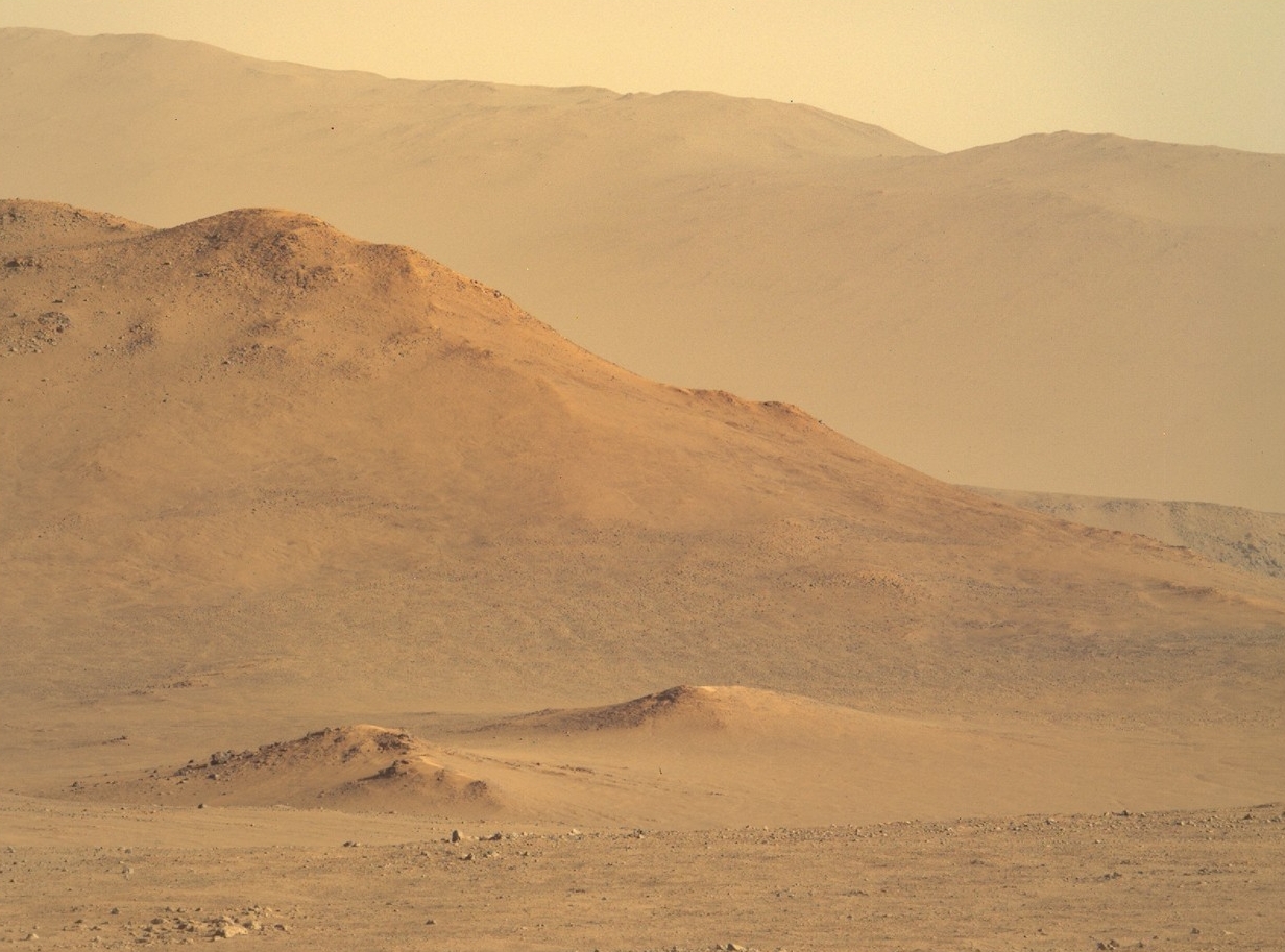 Mountains rise in the background on Mars.