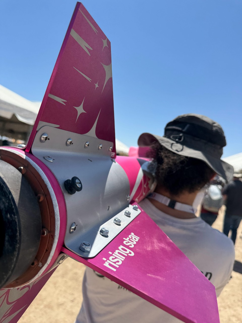 UC students carry their 11-foot-long rocket on their shoulders.