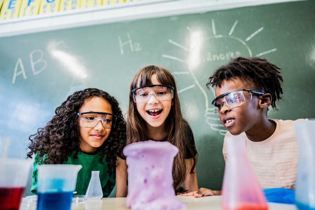 Three middle school students conducting a science experiment in class