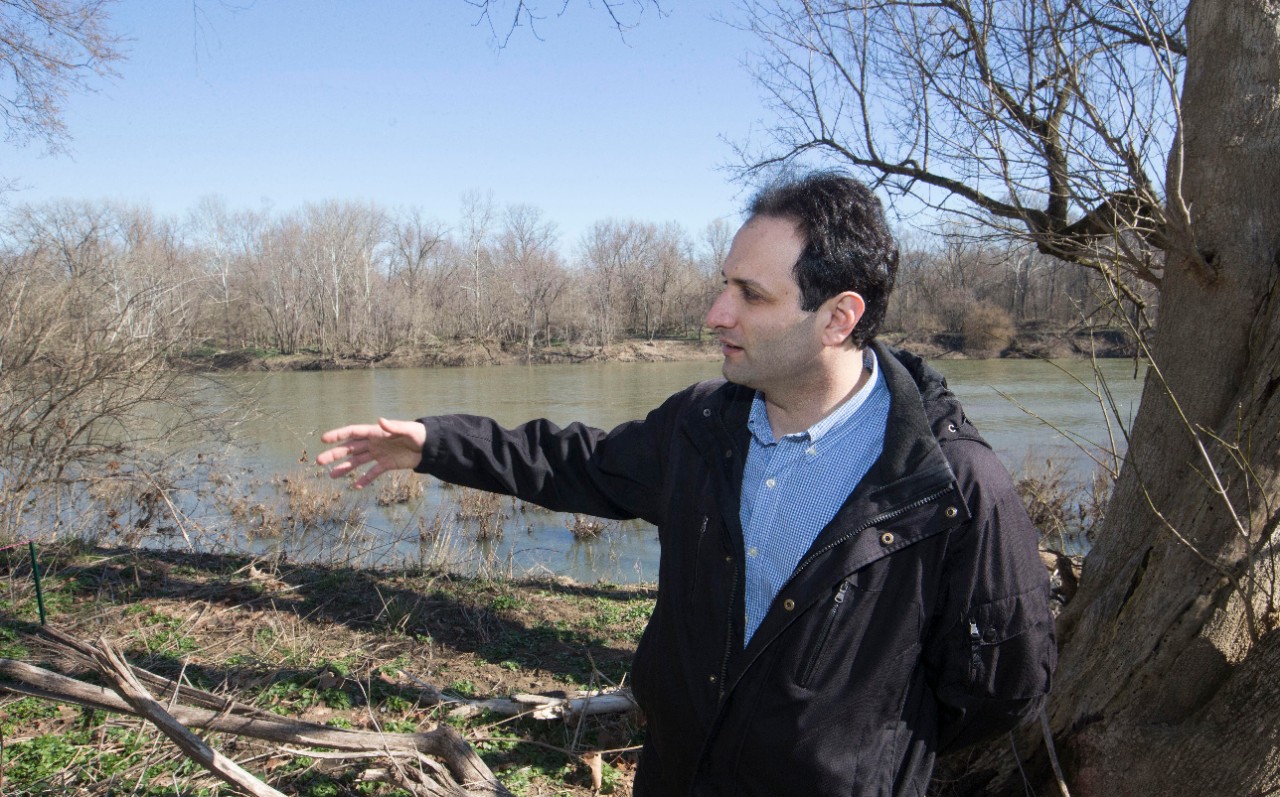 Reza Soltanian stands along the banks of the Great Miami River.